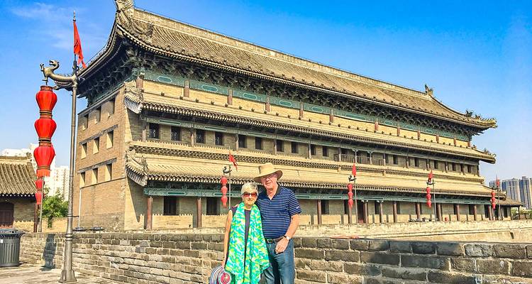 Stel poseert voor een oude stadsmuur.