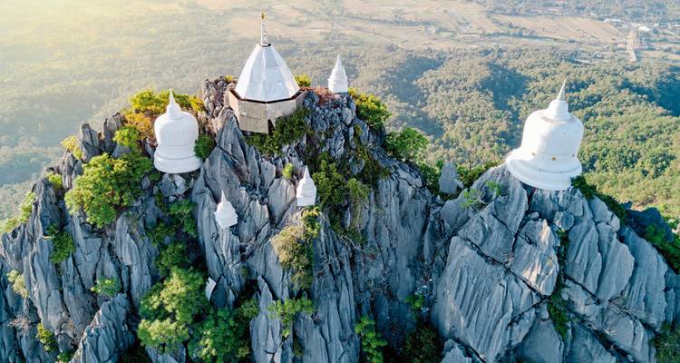 Des pagodes blanches perchées au sommet d'une crête de montagne.