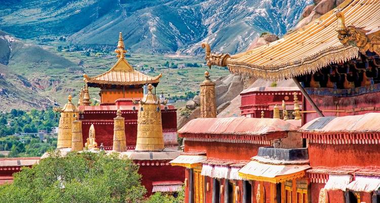 Tibetan architecture with mountains in the background.