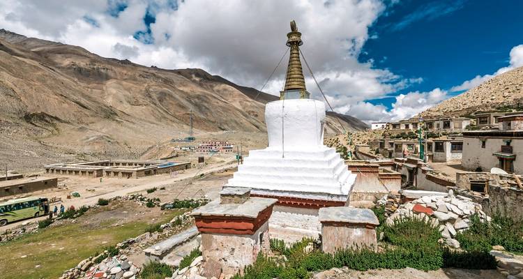 White stupa amidst a Tibetan village setting.