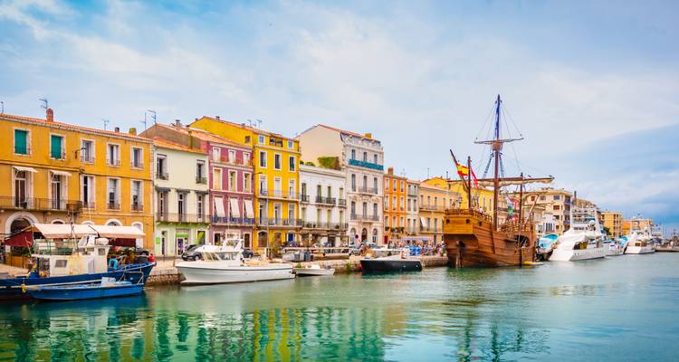 Farbenfrohe Uferfassaden und alte Boote im Kanalhafen von Sète.
