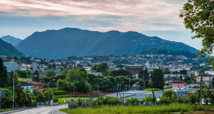 Paysage urbain avec collines environnantes au crépuscule.