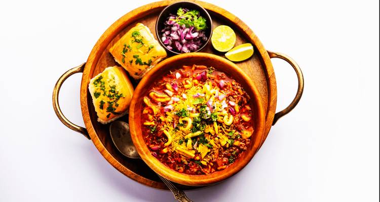 Plat de curry indien servi avec du pain et des garnitures.
