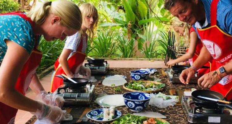 Un grupo de personas participando en una clase de cocina al aire libre.