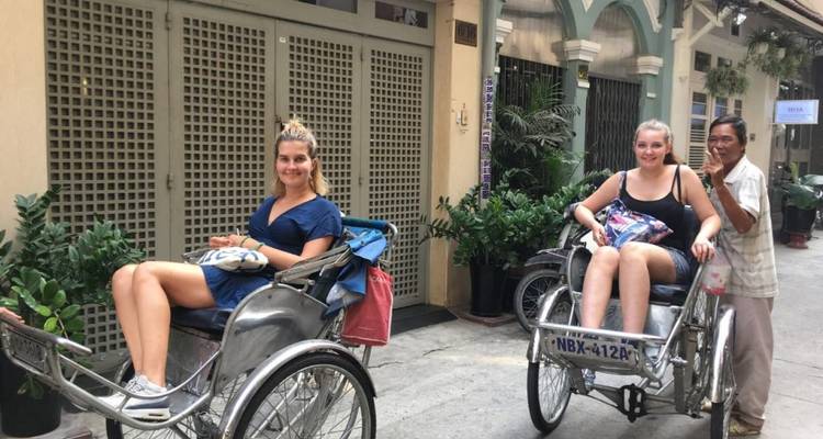 Dos personas montando en rickshaws en una calle urbana.