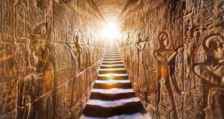 Interior de una tumba con jeroglíficos y escaleras.