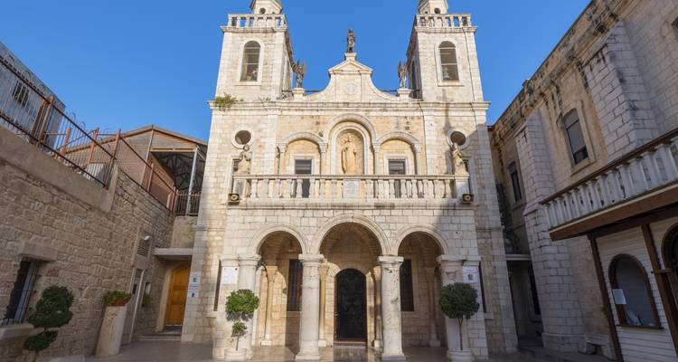 Front view of a stone church with two towers.