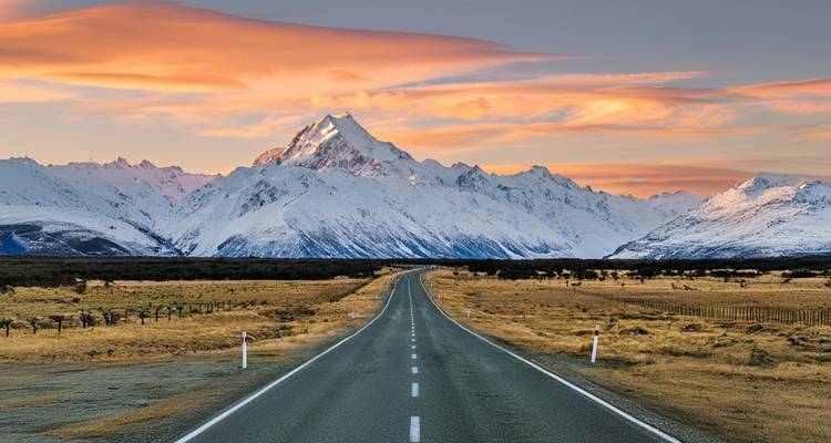 Une route panoramique menant vers une montagne enneigée.