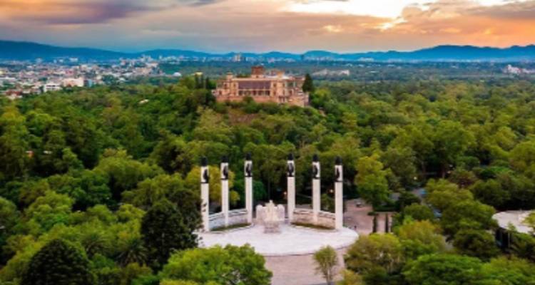 Vista aérea de una ciudad con un monumento y un parque verde exuberante.