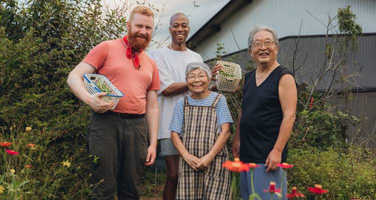 Un groupe de personnes posant avec des paniers près d'un jardin.