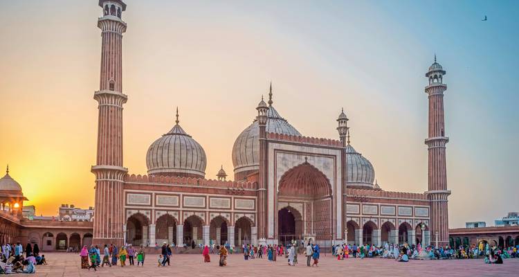 Jama Masjid à Delhi, Inde au coucher du soleil avec des gens autour.