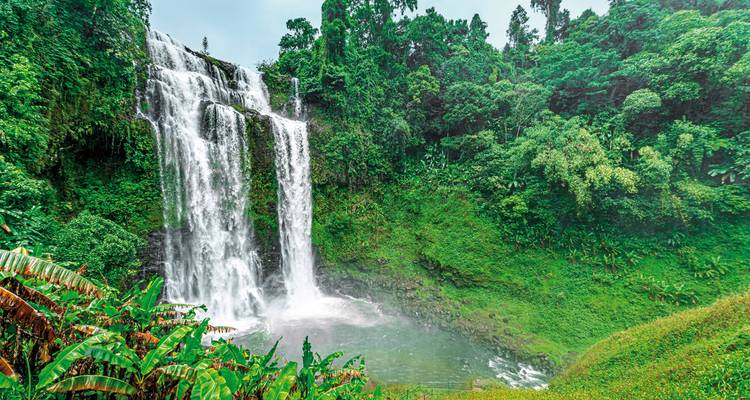 Large waterfall surrounded by lush greenery.