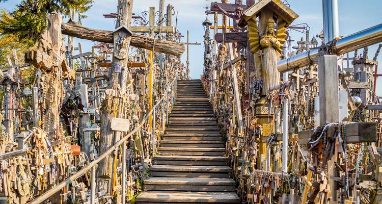 Escalera de madera forrada con miles de cruces, rosarios y tallas religiosas en la Colina de las Cruces.
