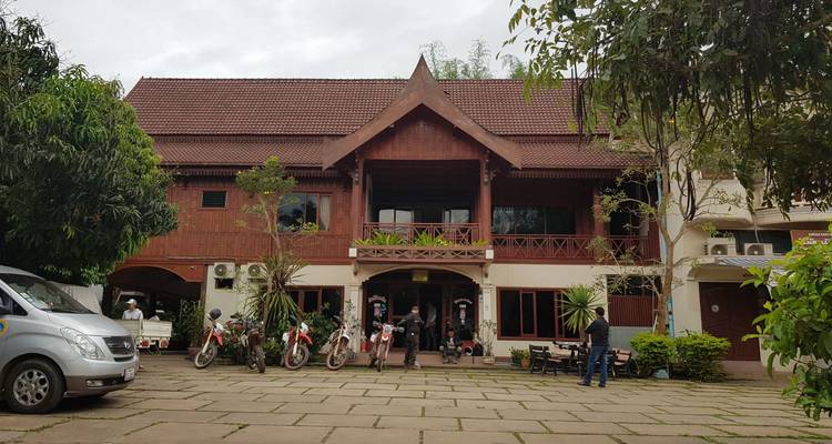 Vooraanzicht van een traditioneel gebouw met fietsen en mensen die buiten staan.