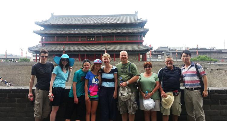 Group of tourists posing in front of an ancient Chinese building.