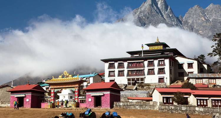 Klooster met bergen en wolken op de achtergrond.
