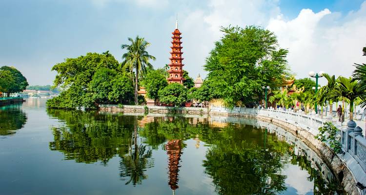 Tran Quoc Pagoda rises above lush trees on a peaceful islet in Hanoi’s West Lake with clear reflections.