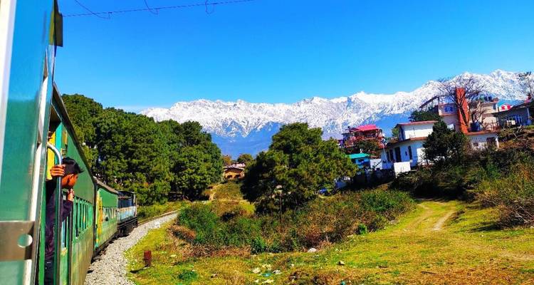 Vue depuis la fenêtre d'un train traversant une région montagneuse.