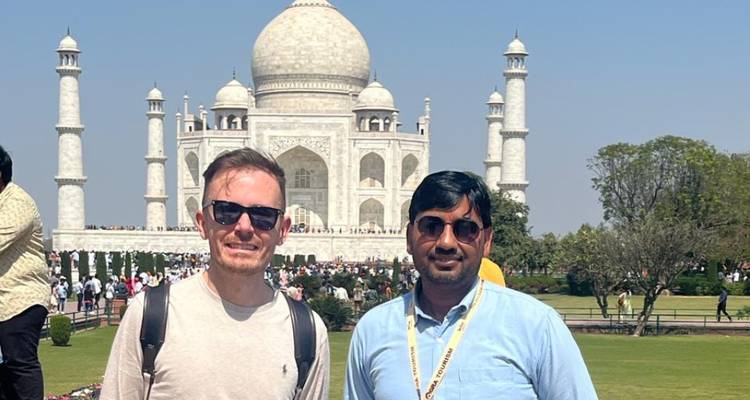 Twee mensen poseren voor de Taj Mahal.