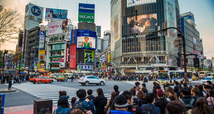 Concurrida intersección de Shibuya rodeada de enormes vallas publicitarias y multitudes esperando