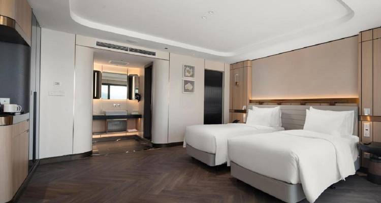 Chambre d'hôtel moderne avec lits jumeaux et décoration minimaliste.