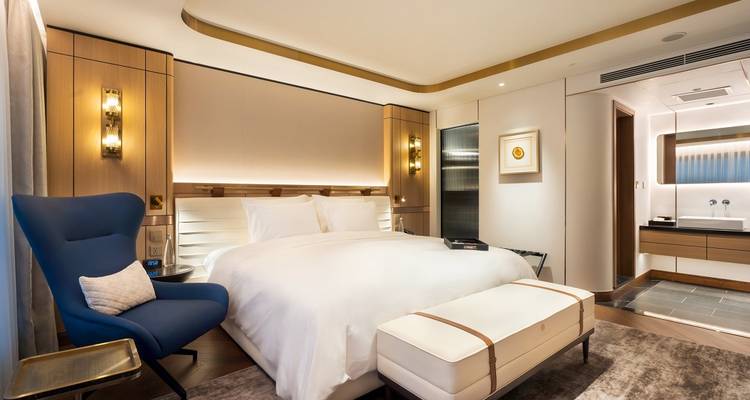 Chambre d'hôtel élégante avec un grand lit et un mobilier luxueux.