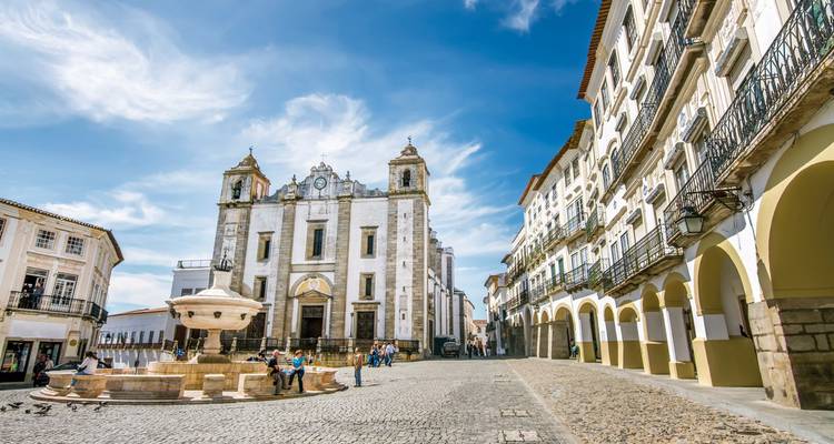 Place historique avec une église et des gens à Évora.