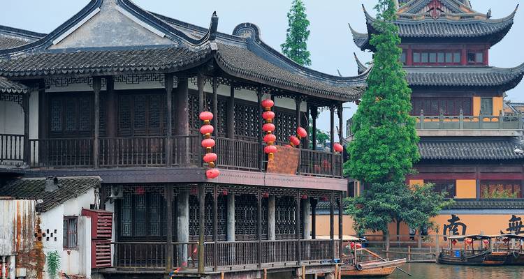 Traditionelle chinesische Gebäude mit roten Laternen an einem Fluss.