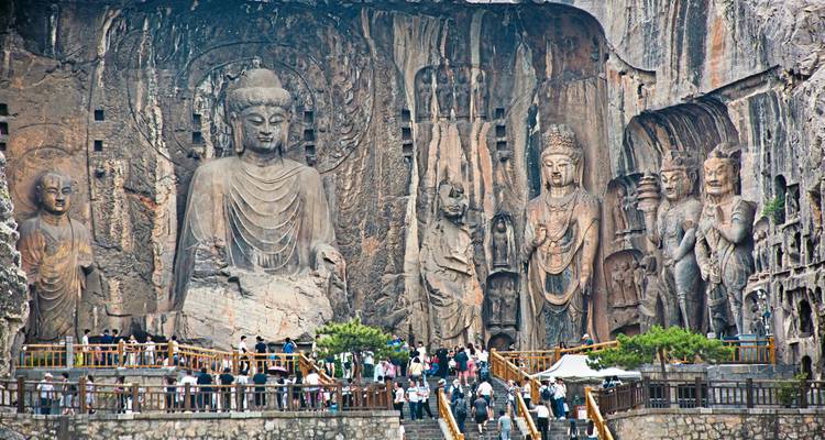 Large stone carvings of Buddhas in a historic site.