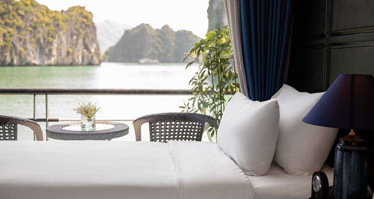 Gezellige hoek van een hotelkamer met bed en uitzicht op de baai.