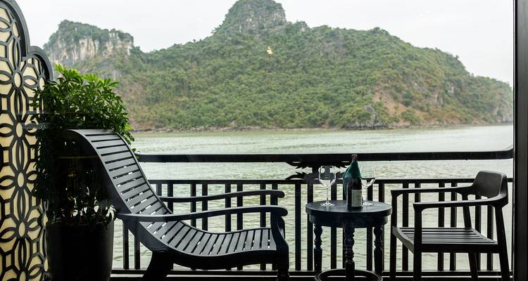 Vue depuis un balcon avec des chaises donnant sur des îles dans une baie.