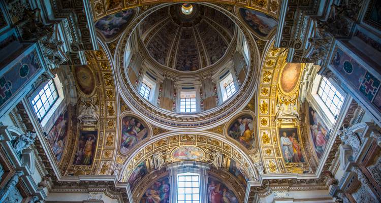 Dôme richement orné et fresques au plafond de l'intérieur d'une église romaine.