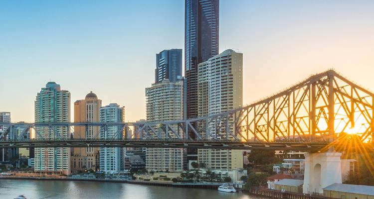Der Sonnenaufgang hebt die Story Bridge von Brisbane mit Spiegelungen im Fluss hervor.