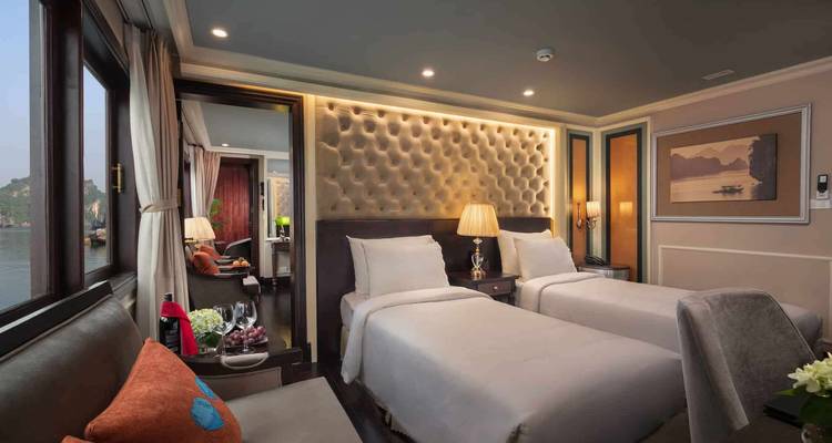 Interior of a hotel room with twin beds and elegant decor.