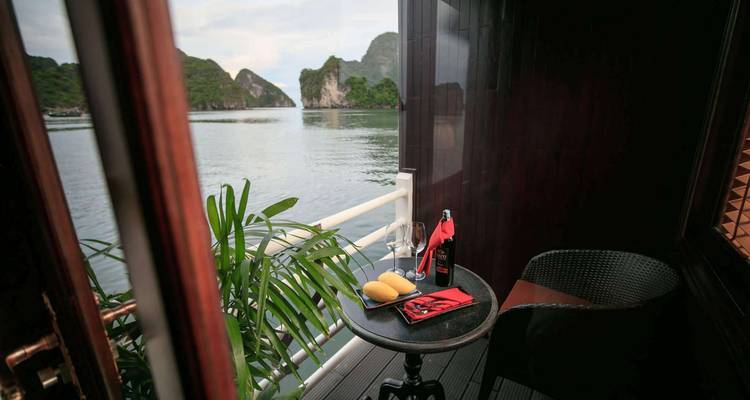 Seating area on a balcony overlooking water and limestone formations