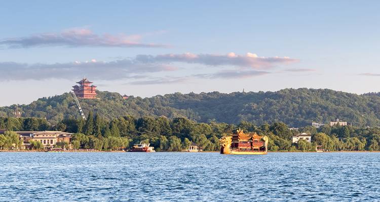 Zicht op een traditionele pagode en boten op een meer.