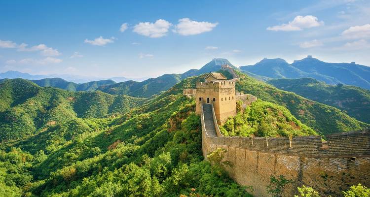 Panoramablick auf die Chinesische Mauer, die sich über grüne Berge unter klarem blauem Himmel windet