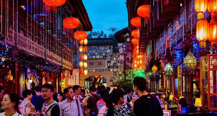 Überfüllte Fußgängerzone in Chengdu, die in der Dämmerung mit leuchtend roten Laternen geschmückt ist