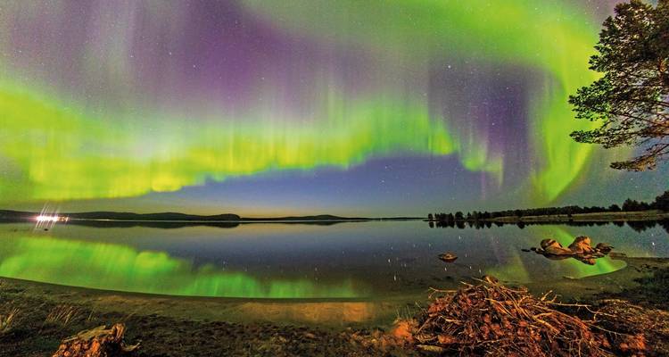 Northern lights over a calm lake reflecting vibrant colors.