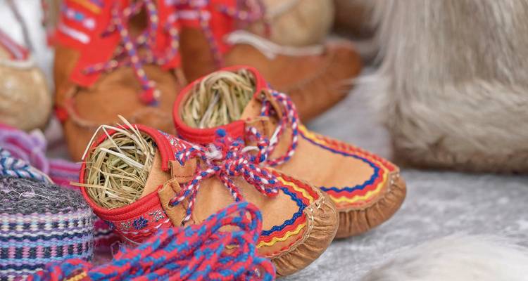 Traditional Sami-style shoes with colorful patterns on display.