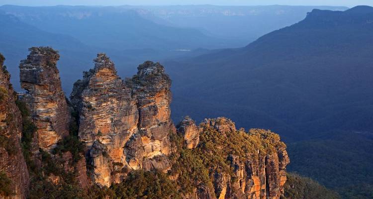 Formations rocheuses connues sous le nom des Trois Sœurs contre un vaste paysage.