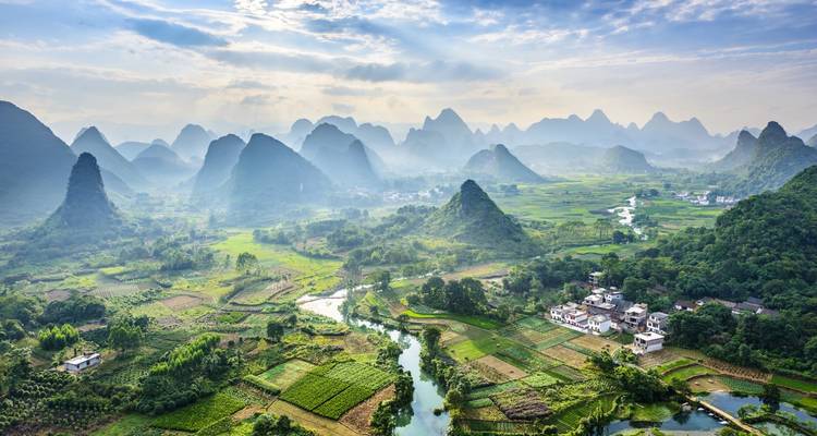 Panoramic view of verdant karst mountains and countryside.