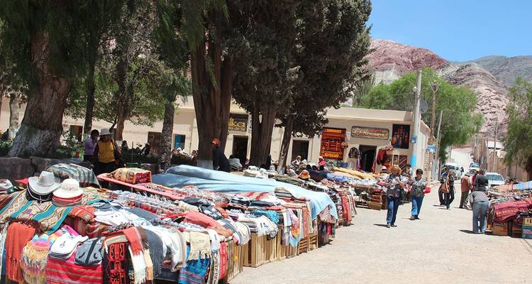 Buitenmarkt met kleurrijke textiel en handwerk.