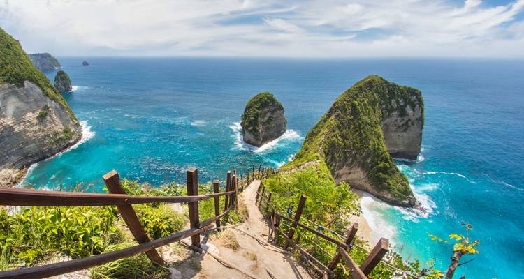 Atemberaubender Blick auf steile Klippen und türkisfarbenes Meer unter einem klaren Himmel.
