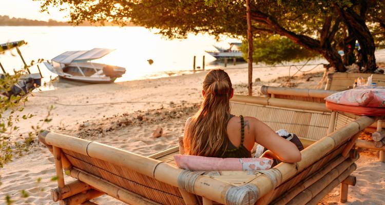 Frau entspannt am Strand während des Sonnenuntergangs.