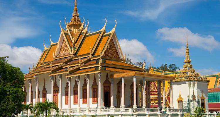 Bâtiment du Palais Royal orné à Phnom Penh agrémenté de flèches dorées et de sculptures complexes sous un ciel dégagé.