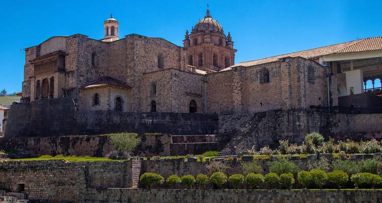 Steinmauern und Kuppel von Qorikancha und des Klosters Santo Domingo in Cusco unter einem strahlend blauen Himmel.