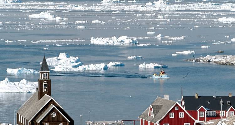 A view over ice-laden waters with a church building nearby.