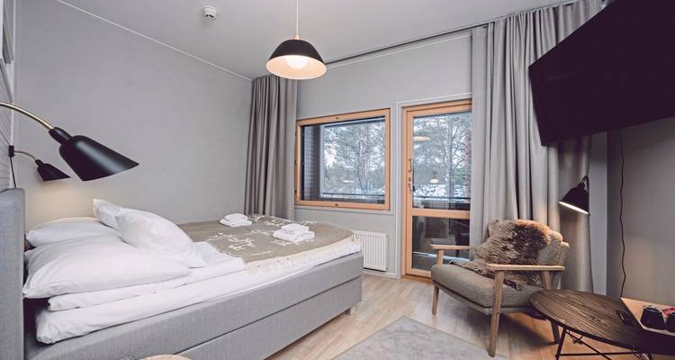 Une chambre d'hôtel confortable avec une grande fenêtre donnant sur les arbres.