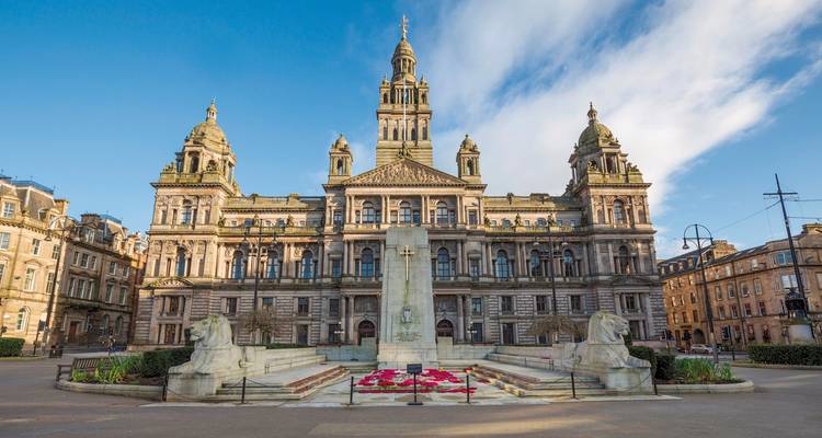Un gran edificio de ayuntamiento con una fuente.